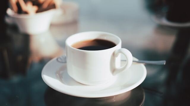 coffee in a simple white coffee cup on a white saucer